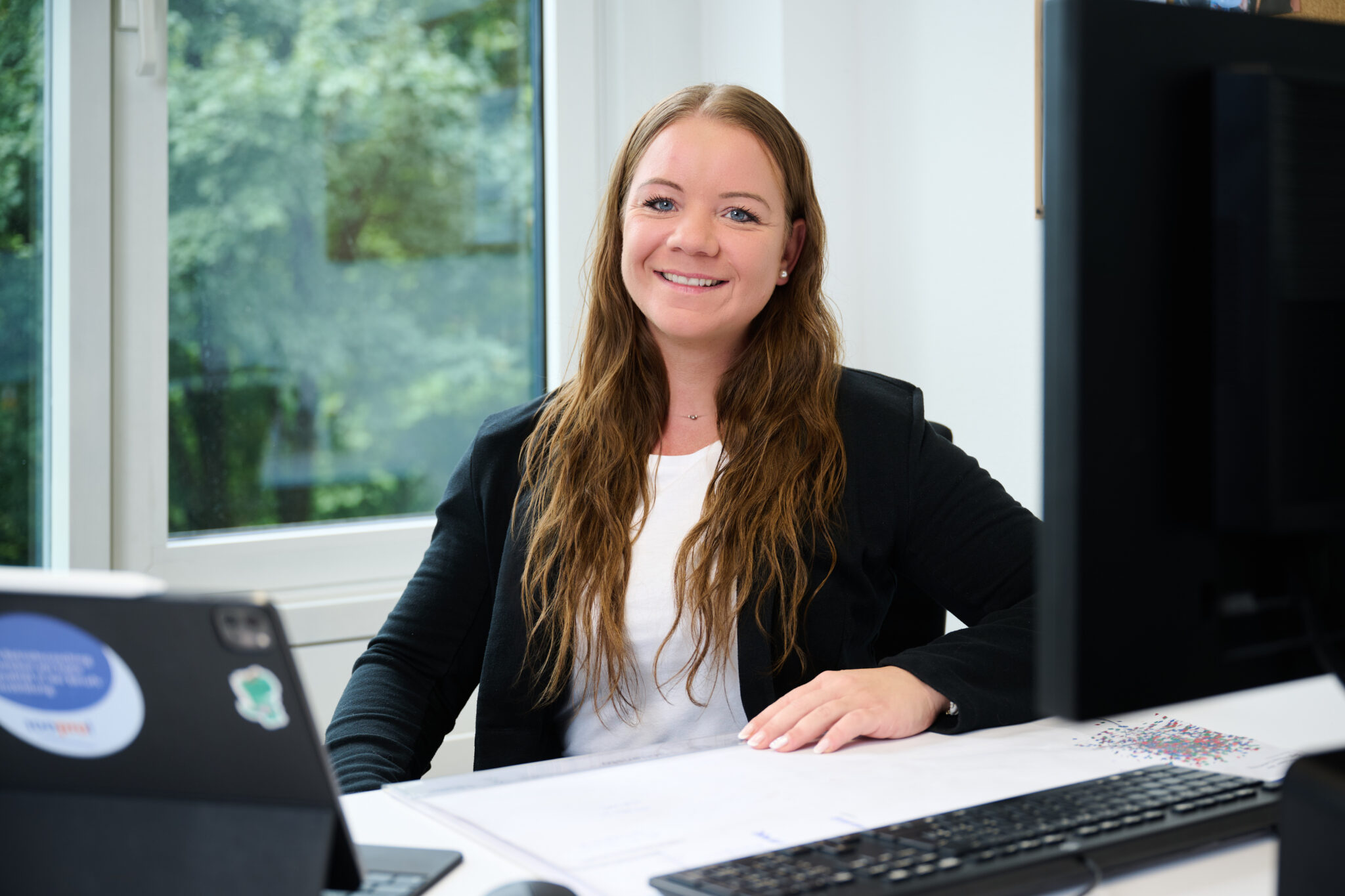 Neue Mitarbeiterin bei 100pro in Schaan, freundlich und professionell im modernen Büro.